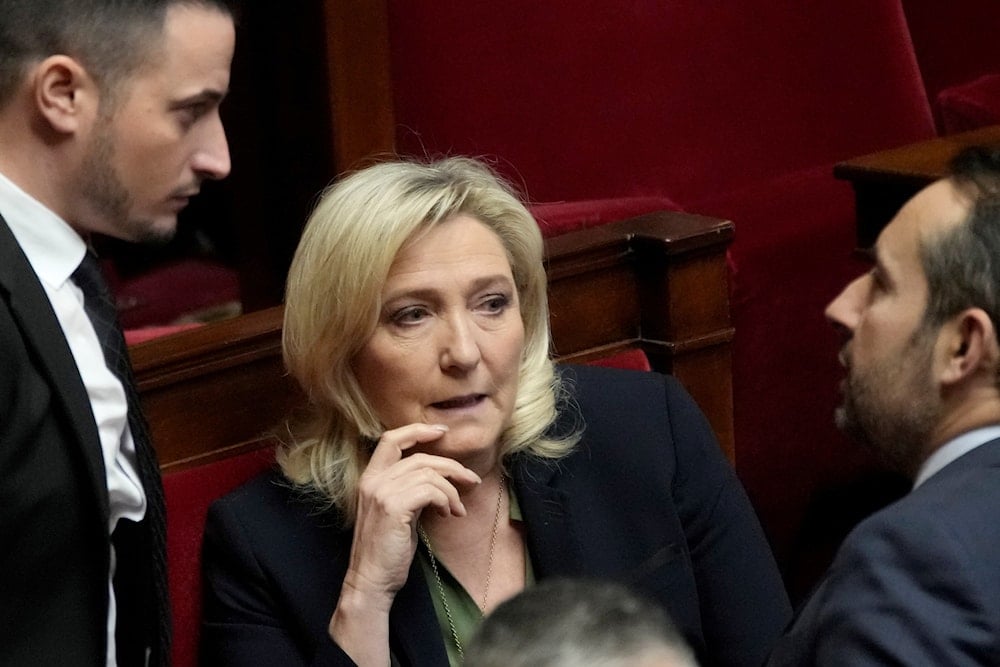 French far-right leader Marine Le Pen talks with National Rally group members at the National Assembly, February 6, 2023 in Paris, France (AP Photo)