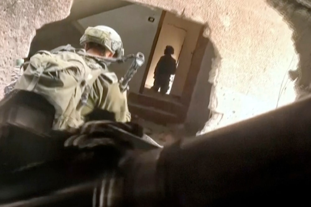 In this image taken from video released by Israeli Occupation Forces, Thursday, Nov 16, 2023, Israeli occupation soldiers wind their way through a hole in a building in the Gaza Strip, occupied Palestine. (AP)