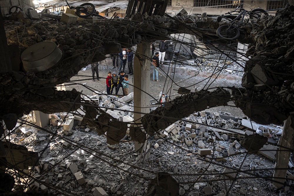 Palestinians look at the destruction after an Israeli strike in Rafah, southern Gaza Strip, January 3, 2024 (AP)