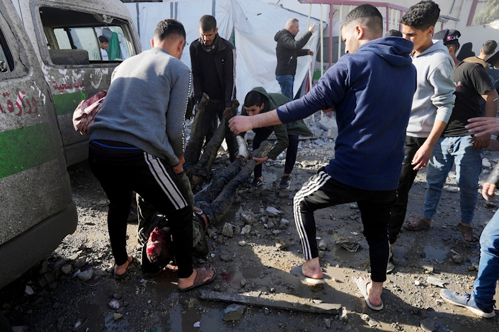 Palestinians remove people killed on the Al-Aqsa Hospital grounds after an Israeli strike hit a building next to it, in Deir al Balah, Gaza Strip, on Wednesday, Jan 10, 2023. (AP Photo/Adel Hana)