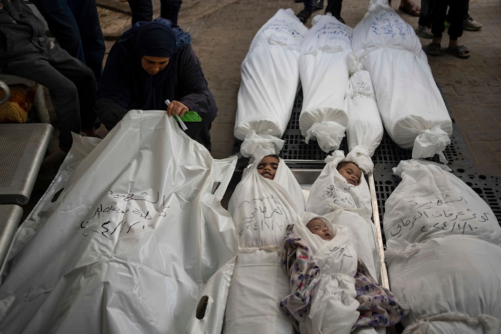 Palestinians mourn their relatives, including kids killed in the Israeli bombardment of the Gaza Strip, outside a morgue in Rafah, southern Gaza, Thursday, Jan. 11, 2024. (AP Photo/Fatima Shbair)