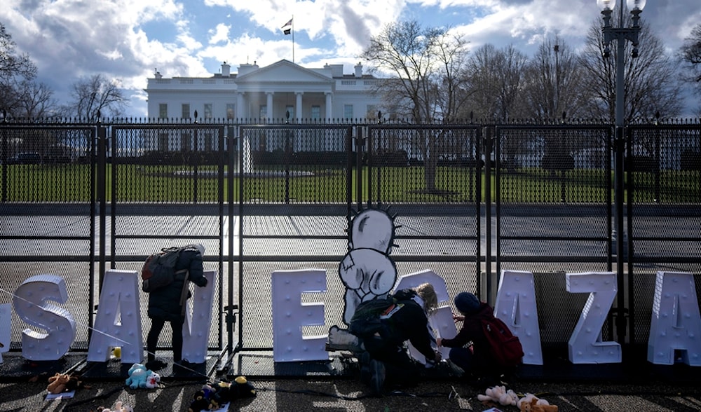 Demonstrators work on a sign reading 'Save Gaza' along a temporary fence outside of the White House ahead of the March on Washington for Gaza on Saturday, Jan. 13, 2024, in Washington, USA. (AP)