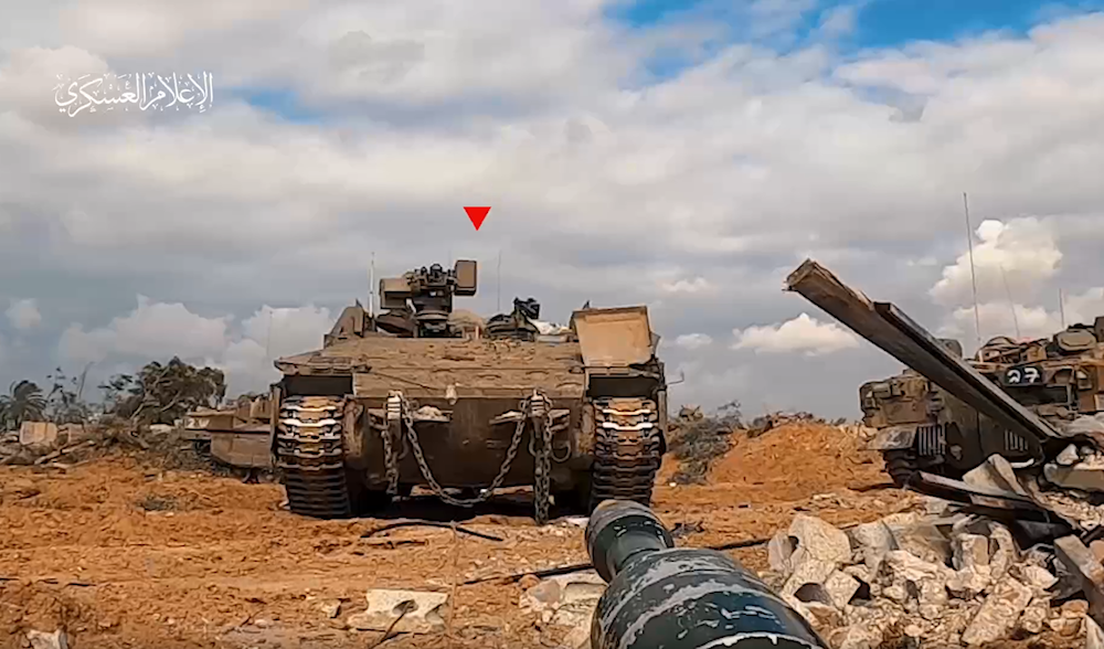 A screenshot from a video released by the al-Qassam military media on January 13, 2024, of a Resistance fighter targeting an Israeli occupation tank from incredibly close range. (Military media)