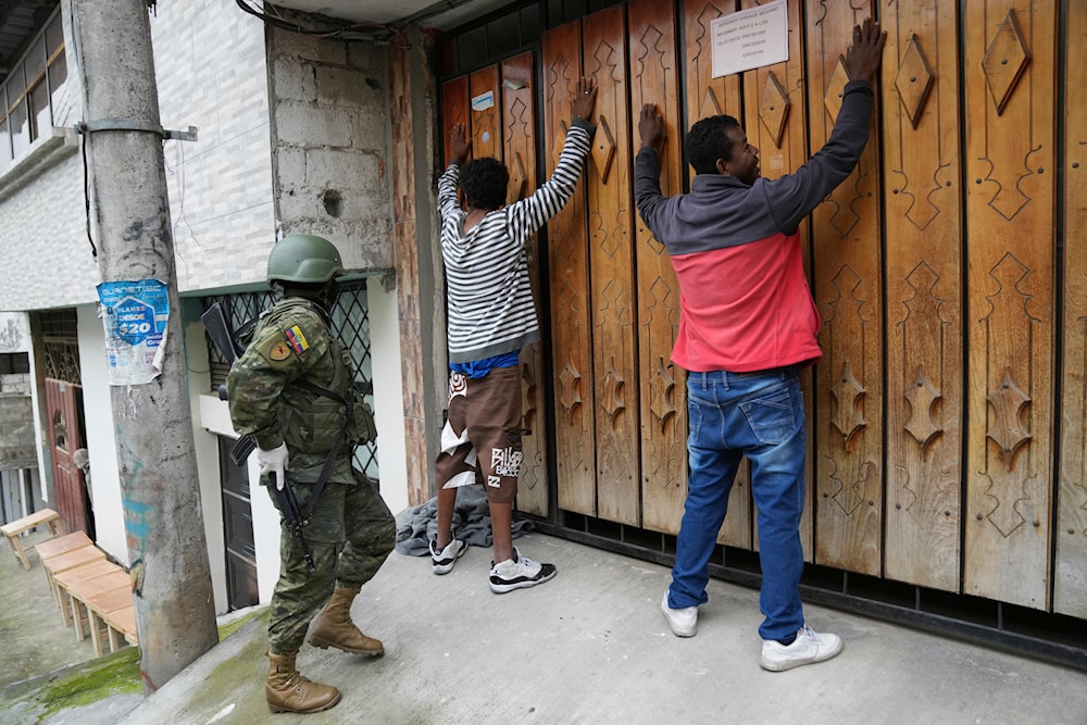 Residents stand still with their hands up for a soldier who will search them as the military patrols the south side of Quito, Ecuador, Friday, Jan. 12, 2024. (AP)