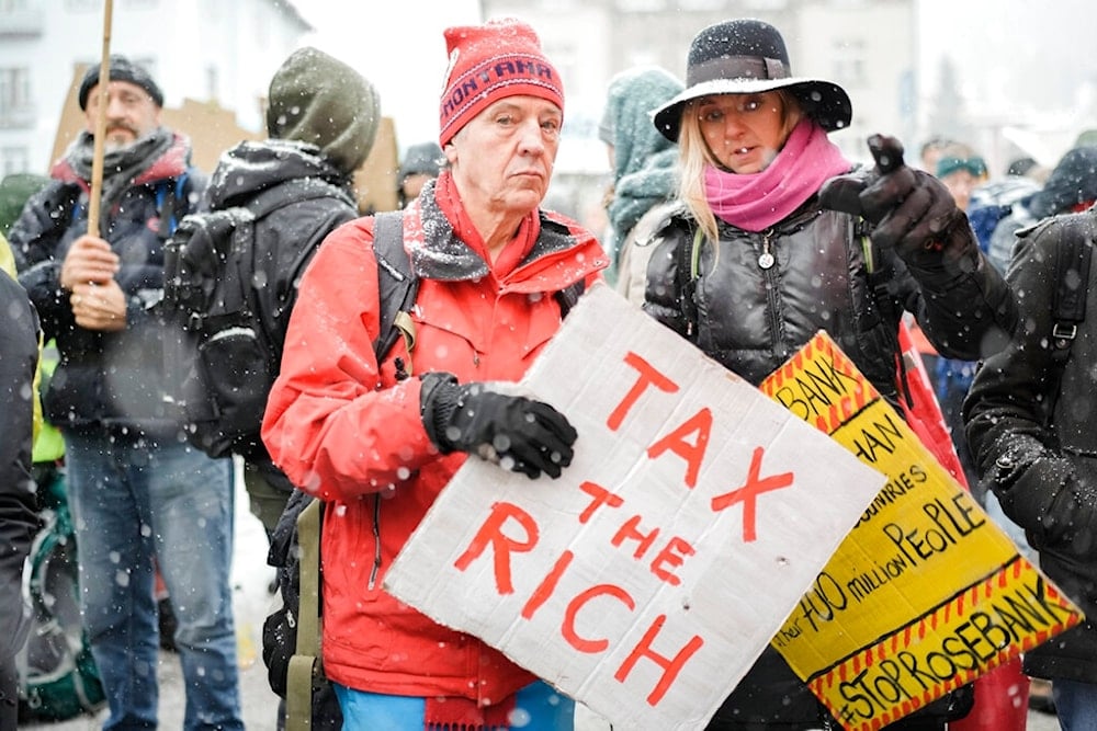 People attend a demostration against the annual meeting of the World Economic Forum in Davos, Switzerland Sunday, Jan. 15, 2023 (AP)