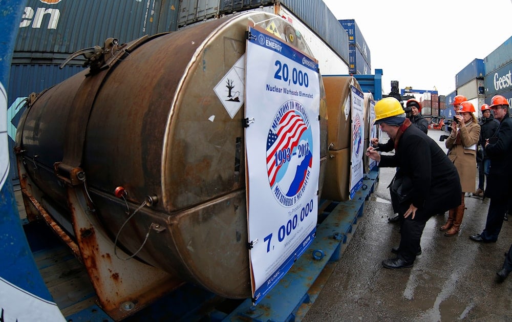 Representatives of participating companies sign containers with uranium to be used as fuel for nuclear reactors, prior to loading them aboard Atlantic Navigator ship, on a port in St. Petersburg, Russia, Thursday, Nov. 14, 2013