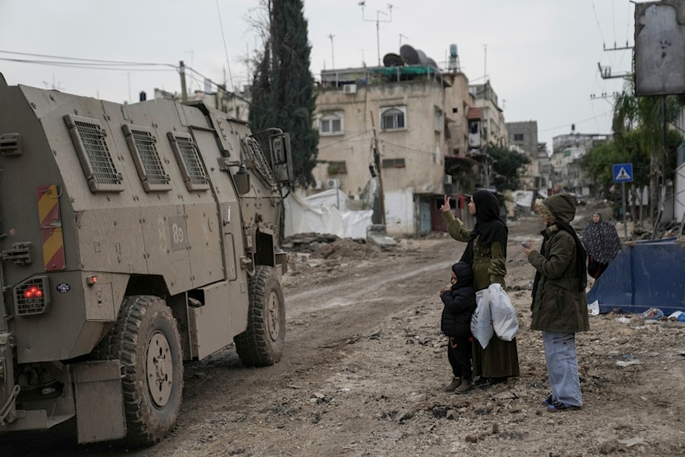 A Palestinian woman flashes a V-sign towards Israeli troops during an army raid in the Tulkarem refugee camp, West Bank, Wednesday, Jan.17, 2024. (AP)