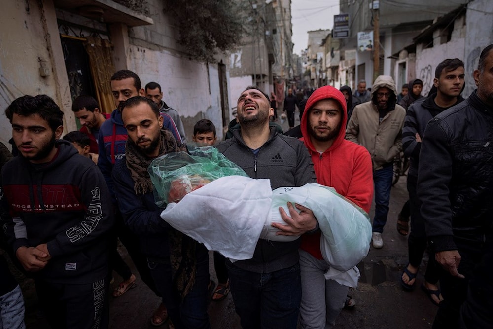 Mohammad Shouman carries the body of his daughter, Masa, who was killed in an Israeli bombardment of the Gaza Strip, during her funeral in Rafah, southern Gaza, Wednesday, Jan. 17, 2024. (AP)