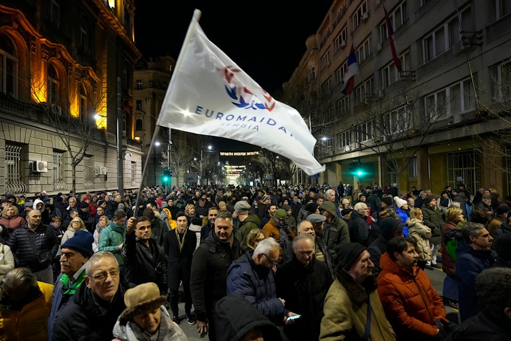 A protester waves a flag that reads: 'EUROMAIDAN Serbia' during a rally in downtown Belgrade, Serbia, Tuesday, Jan. 16, 2024. (AP)