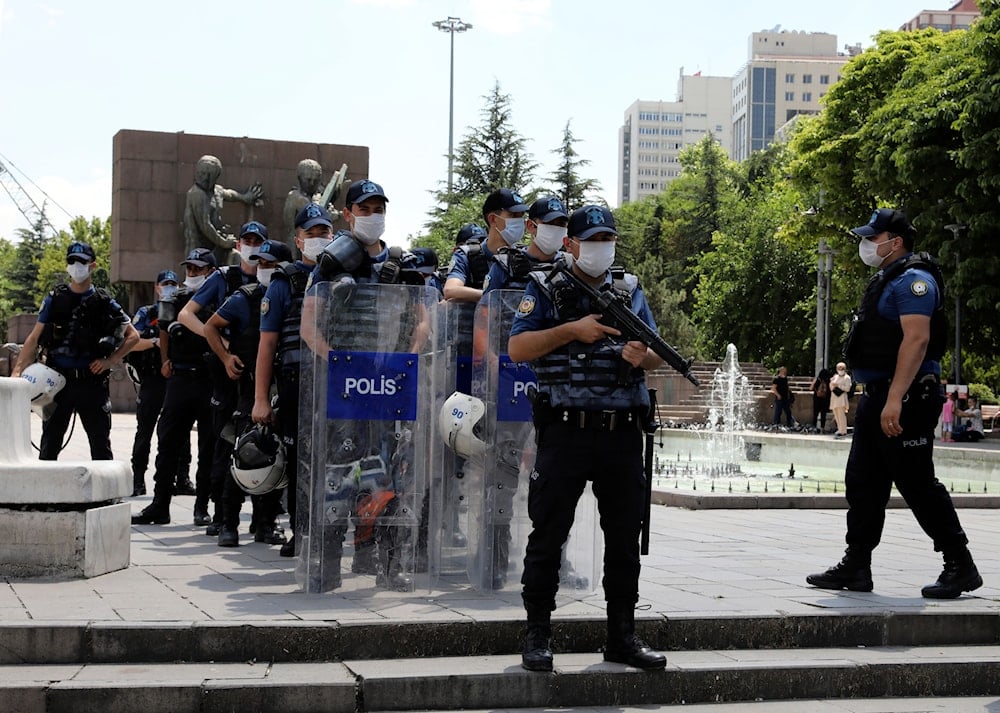 Riot police officers stand as lawyers march to the city's main courthouse as the heads of Turkish lawyers' associations wait for a second day to enter the parliament, in Ankara, Turkey, Friday, July 3, 2020. (AP)