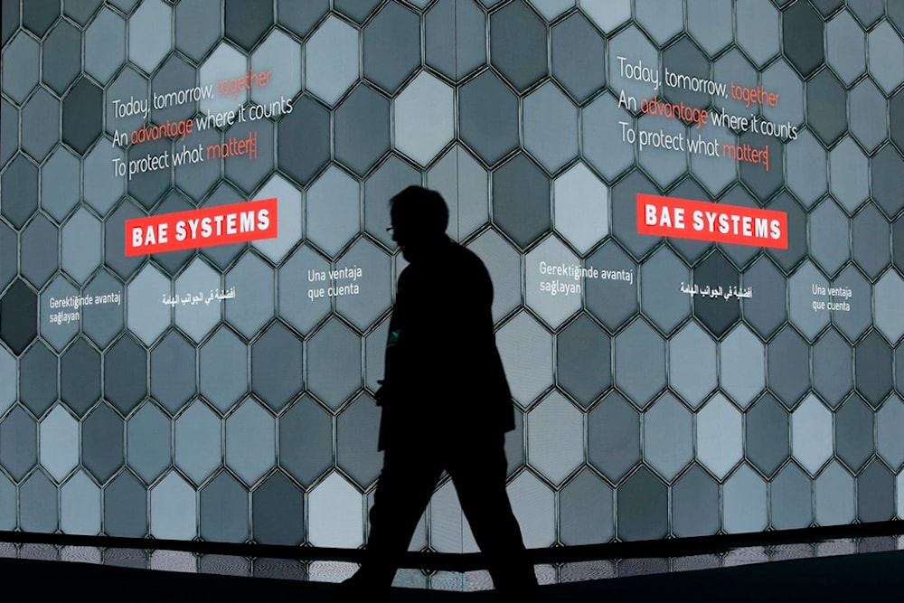 A man walks past a screen in the BAE Systems chalet at the Farnborough Airshow in Farnborough, England, on July 16, 2018 (AP)