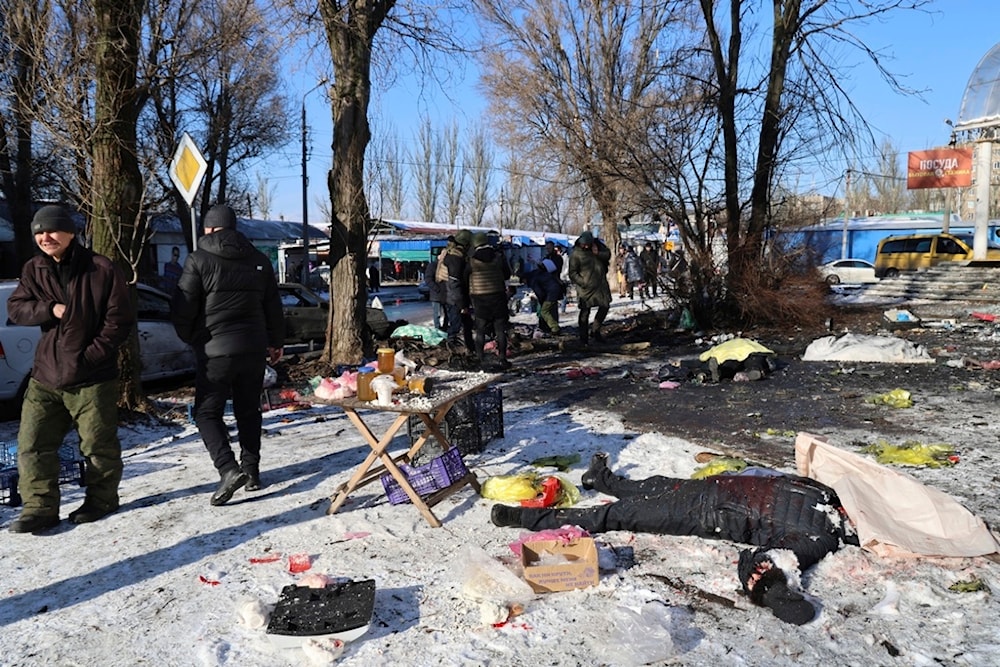  People walk past bodies of victims killed during the Ukrainian shelling on the Donetsk, Sunday, Jan. 21, 2024.