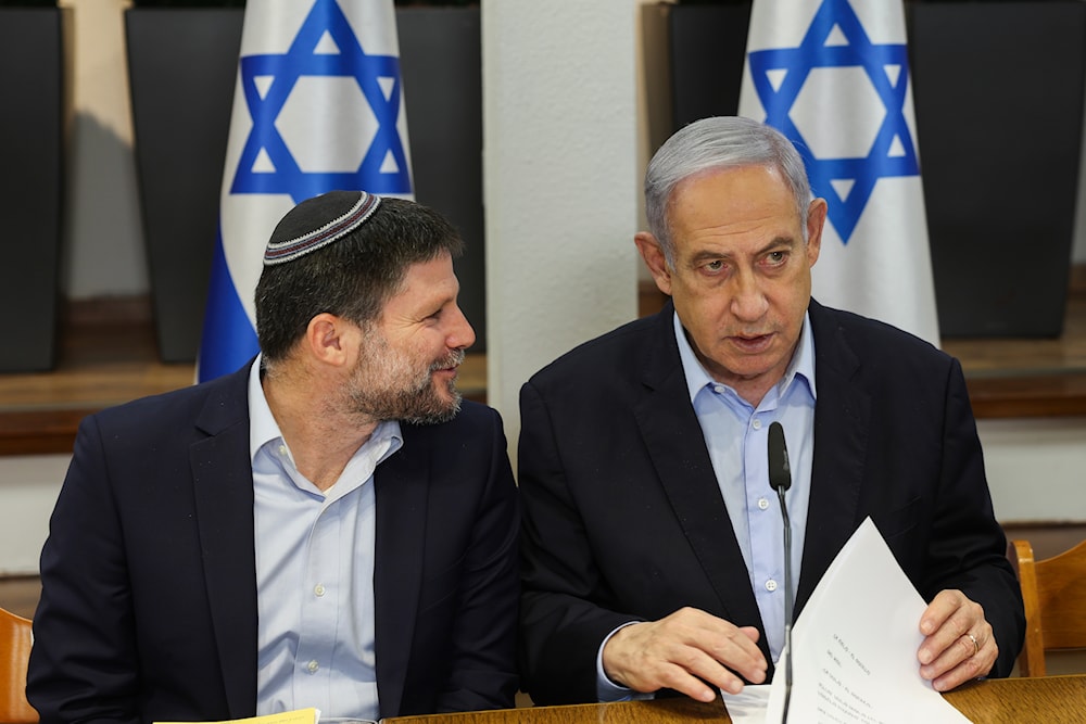 Israeli Prime Minister Benjamin Netanyahu, right, speaks with Minister of Finance Bezalel Smotrich during the weekly cabinet meeting at the Security Ministry in 'Tel Aviv', occupied Palestine, January 7, 2024 (AP)