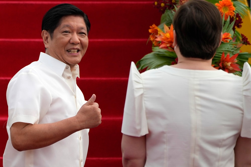 Philippine President Ferdinand Marcos Jr., gestures to Vice-President Sara Duterte as he boards a plane for China on Tuesday, Jan. 3, 2023, at the Villamor Air Base in Manila, Philippines.(AP)
