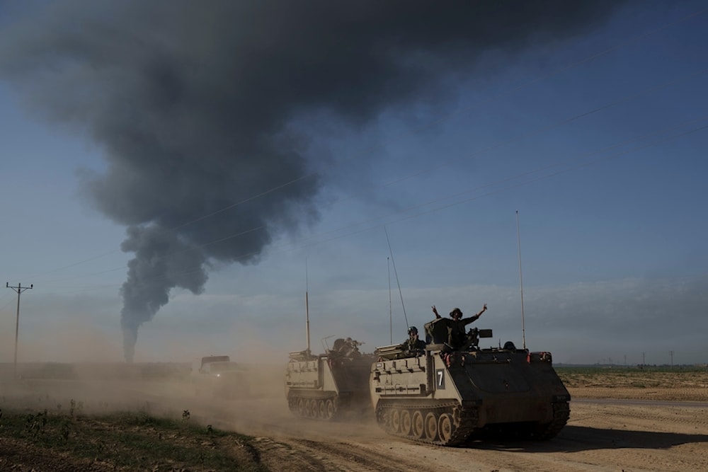 Israeli soldiers move on armored personnel carriers (APC) near the Israeli-Gaza border as smoke rises to the sky in the Gaza Strip, seen from southern Palestine, Sunday, Jan. 21, 2024. (AP)
