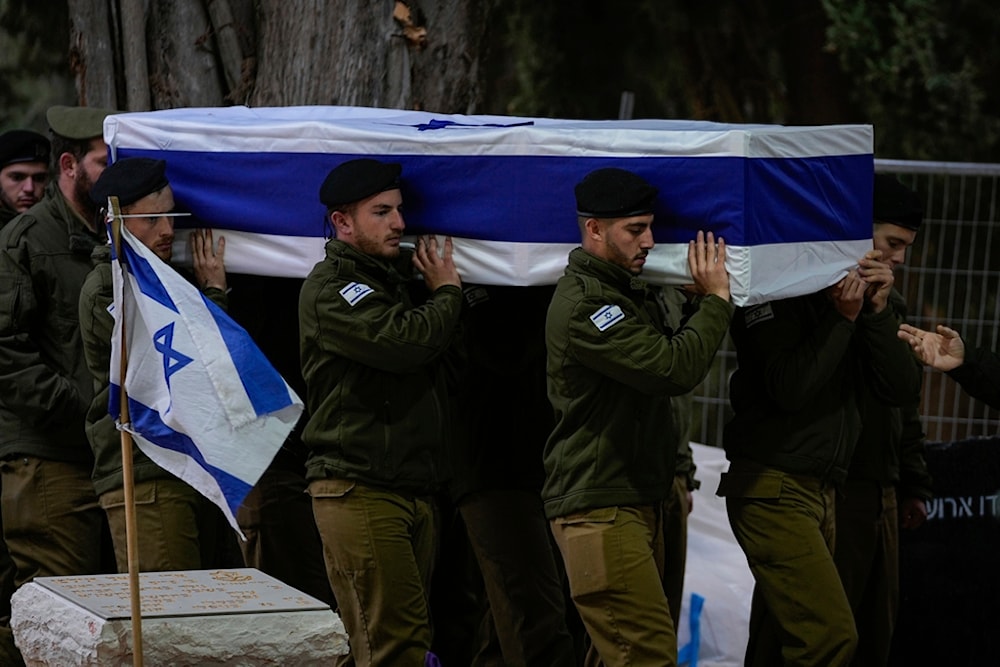 Israeli soldiers carry the flag-draped casket of reservist Hadar Kapeluk during his funeral at Mt. Herzl military cemetery in occupied al-Quds, Tuesday, Jan. 23, 2024 (AP)