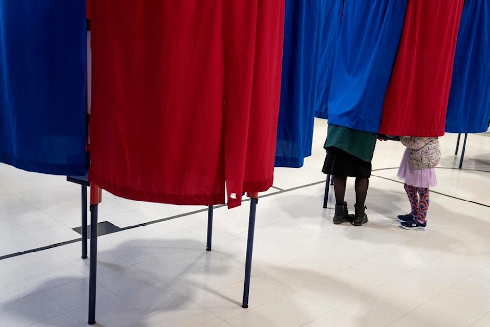 Kara Simard, left, votes with her daughter, Violet, 5, in the New Hampshire presidential primary at a polling site in Manchester, N.H., Tuesday, Jan. 23, 2024. (AP)