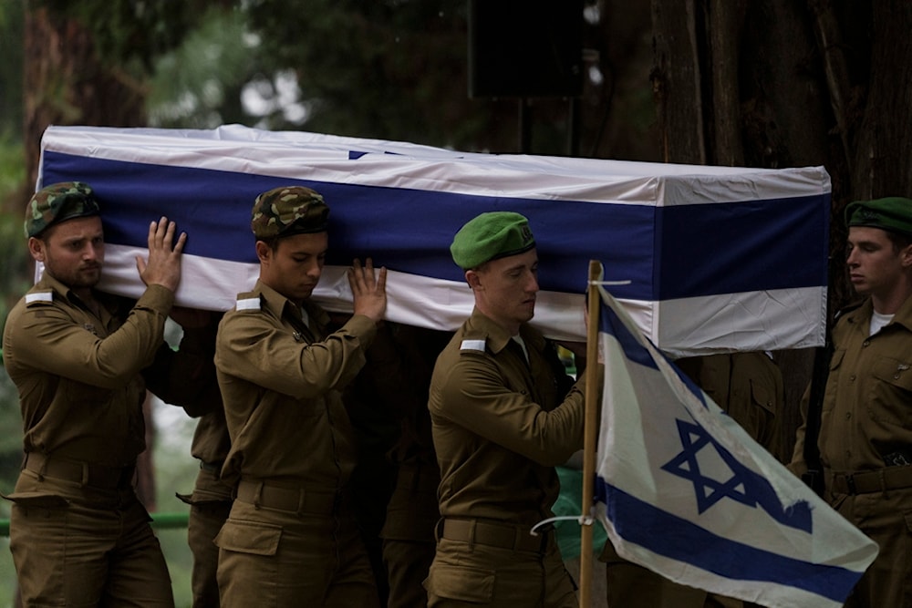 Israeli occupation soldiers carry the flag-draped casket of reservist Sgt. first class Nicholas Berger during his funeral at Mt. Herzl military cemetery in Occupied Al Quds, Occupied Palestine, Wednesday, Jan. 24, 2024 (AP)