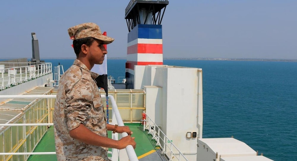 A Yemeni soldier stands aboard the Israeli-linked Galaxy Leader ship, captured last month by Ansar Allah. (AFP)
