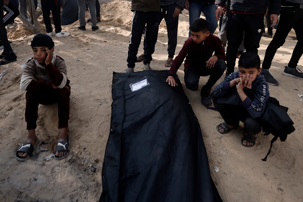 Palestinians mourn a relative killed in the Israeli bombardment of the Gaza Strip outside a morgue in Khan Younis on Monday, Jan. 22, 2024. (AP)
