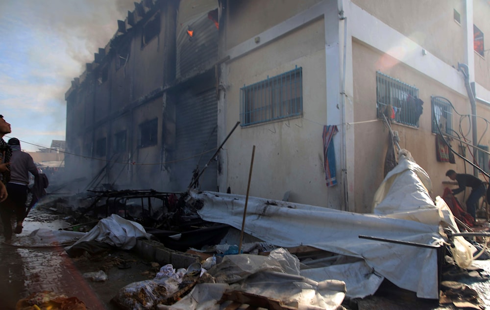 Palestinians try to extinguish a fire at a building of an UNRWA vocational training center which displaced people use as a shelter, after being targeted by Israeli tank shill in Khan Younis, southern Gaza Strip, Wednesday, Jan. 24, 2024. (AP)