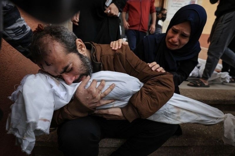 A Palestinian father holds the body of one of his children killed in Israeli bombardment, in Khan Younis in the southern Gaza Strip on November 19, 2023. (AFP)