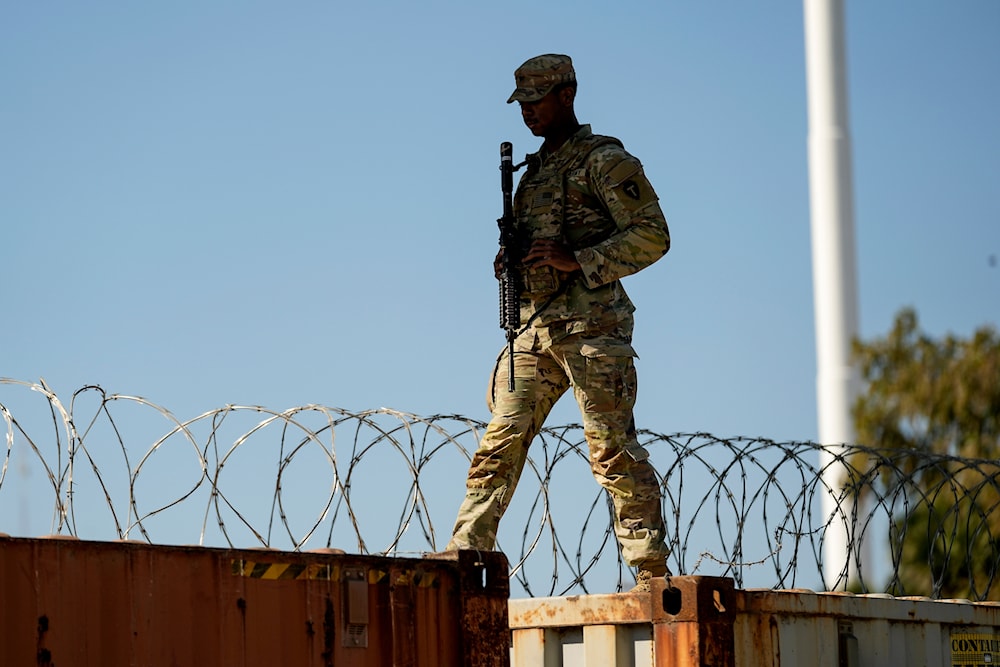 A guardsman walks over rail cars with Concertina wire along the Texas-Mexico border, January 3, 2024, in Eagle Pass, Texas (AP) 