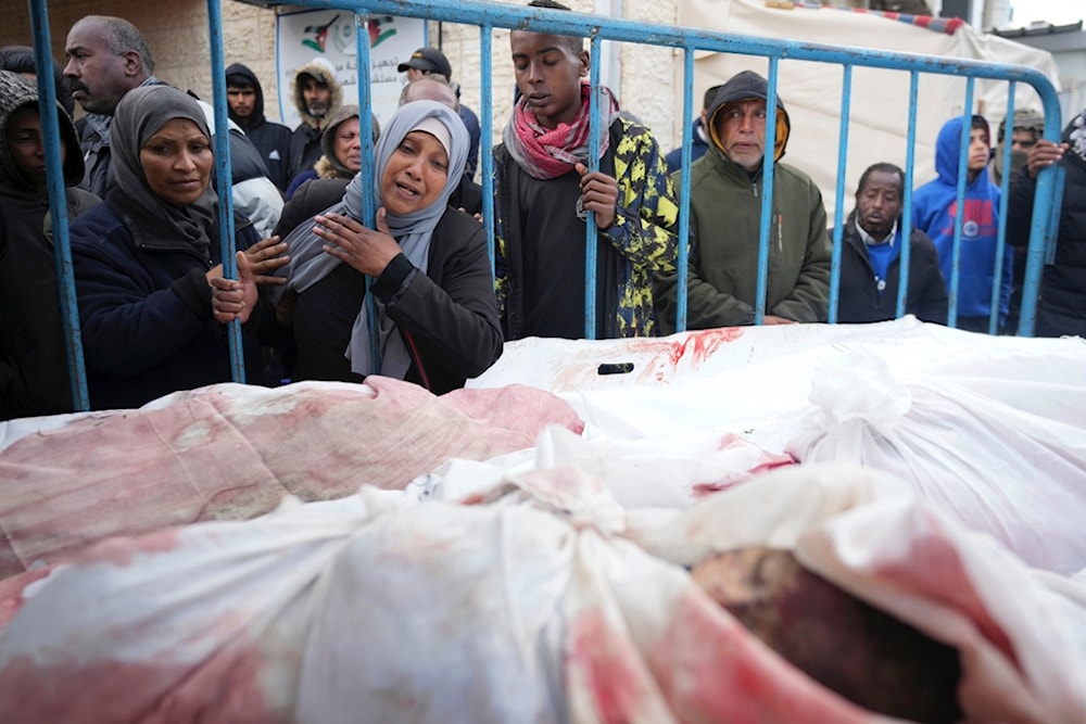 Palestinians mourn the relatives killed in the Israeli genocide in the Gaza Strip at a hospital in Deir al Balah on Friday, Jan. 26, 2024. (AP)