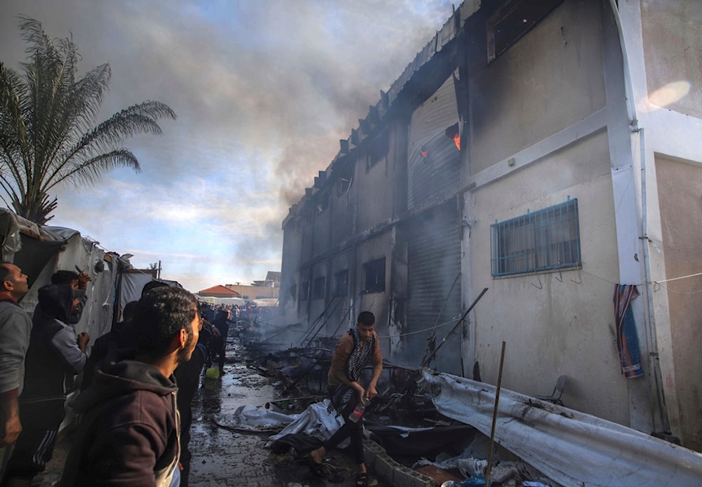 Palestinians try to extinguish a fire at a building of an UNRWA vocational training center which displaced people use as a shelter, after being targeted by Israeli tank shill in Khan Younis, southern Gaza Strip, Wednesday, Jan. 24, 2024. (AP)