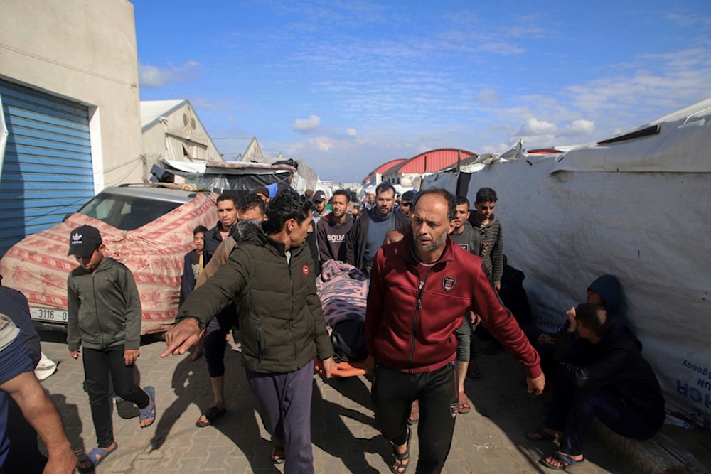 Palestinians carry a a body of a person killed in the Israeli bombardment at a building of an UNRWA vocational training center which displaced people use as a shelter in Khan Younis, southern Gaza Strip, Wednesday, Jan. 24, 2024 (AP Photo/Ramez Habboub)