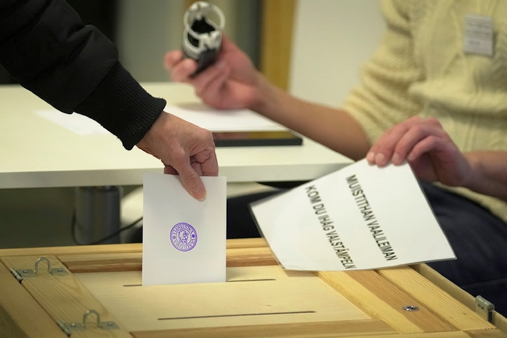 A woman casts her ballot at a polling station during presidential election in Helsinki, Finland, Sunday, Jan. 28, 2024. (AP)