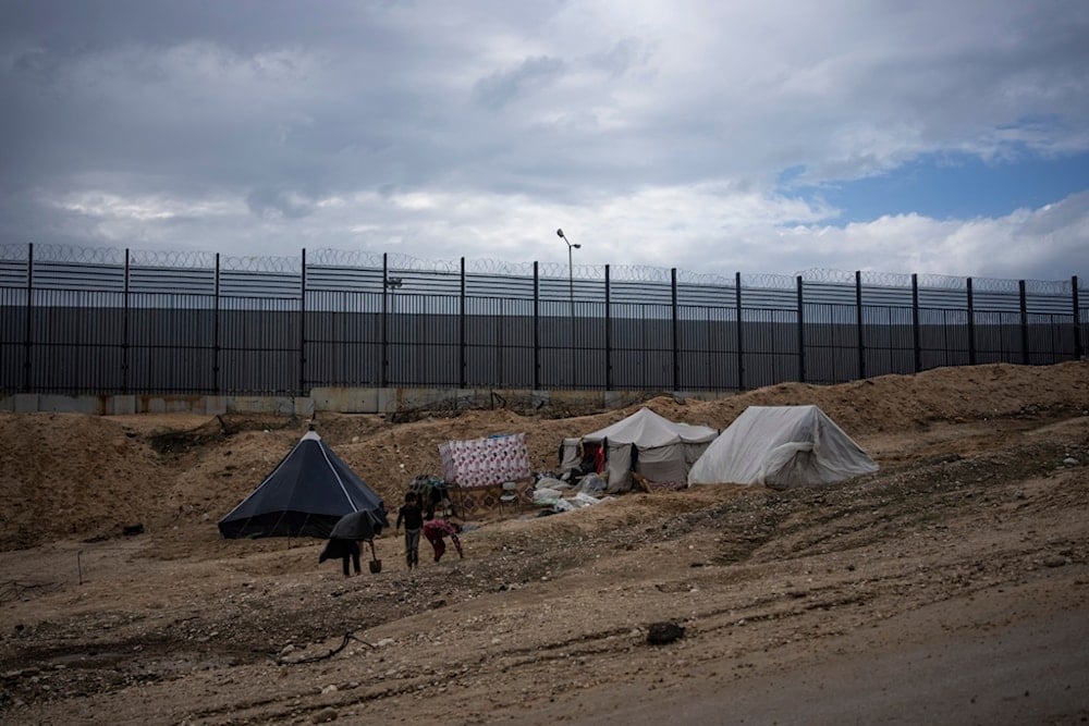 Palestinians displaced by the Israeli air and ground attacks on the Gaza Strip walk through a makeshift tent camp in Rafah on the border with Egypt, Saturday, Jan. 27, 2024 (AP Photo/Fatima Shbair)
