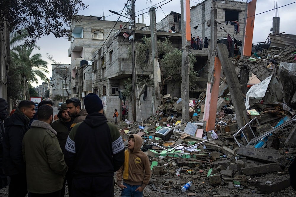 Palestinians look at the destruction after an Israeli strike in Rafah, southern Gaza Strip, January 27, 2024 (AP)