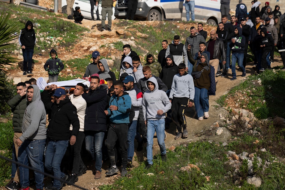 Mourners carry the body of Palestinian Abdel Rahman Hamed, 18, during his funeral in the West Bank town of Silwad, January 29, 2024 (AP)