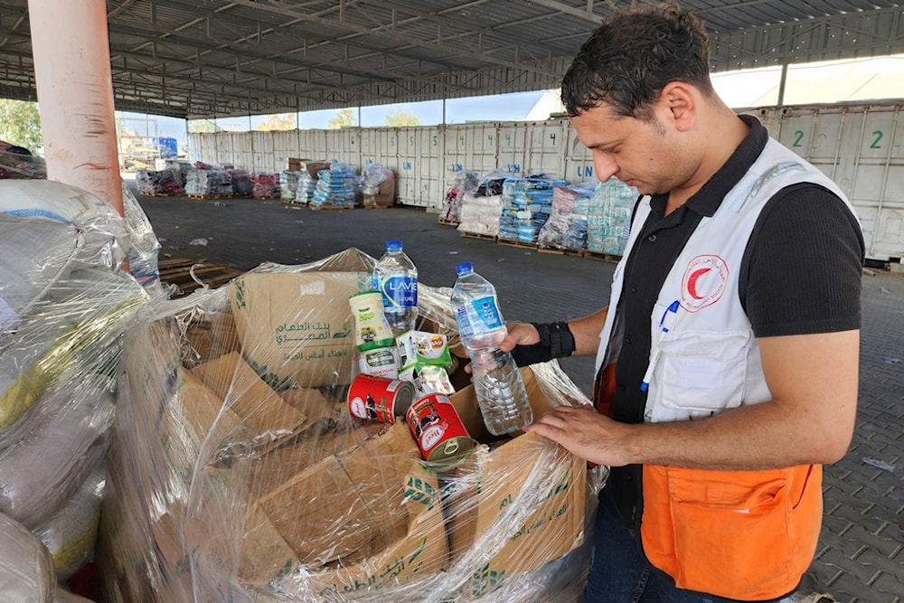 United Nations and Red Crescent workers prepare the aid for distribution to Palestinians at UNRWA warehouse in Deir Al-Balah, Gaza Strip, on Monday, Oct. 23, 2023. (AP)