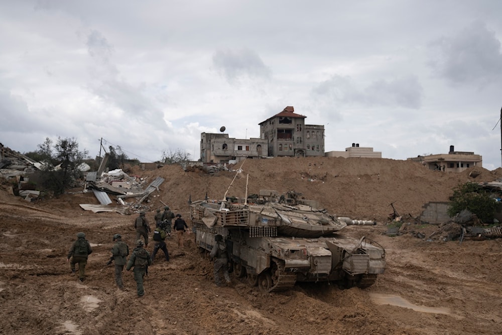 IOF soldiers walk by a tank during the ground invasion on the Gaza Strip in Khan Younis, Saturday, Jan. 27, 2024. (AP Photo/Sam McNeil)