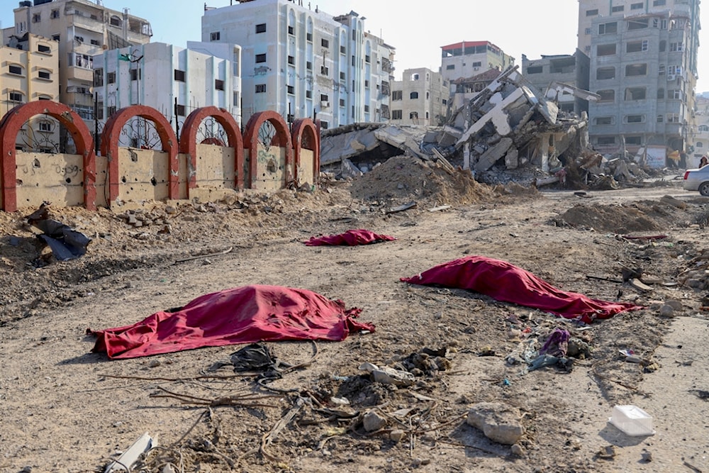 Bodies of Palestinians who were killed in the Israeli bombardment of the Gaza Strip are covered in the main road in Gaza City on Tuesday, Jan. 2, 2024 (AP Photo/Mohammed Hajjar)