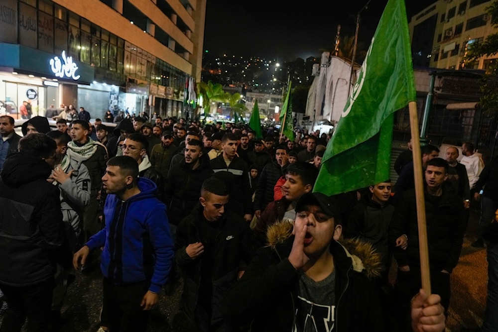  Palestinian demonstrators wave Hamas flags and shout slogans during a protest following the killing of top Hamas official Saleh Arouri in Beirut, in the West Bank city of Nablus on Jan. 2, 2024. 