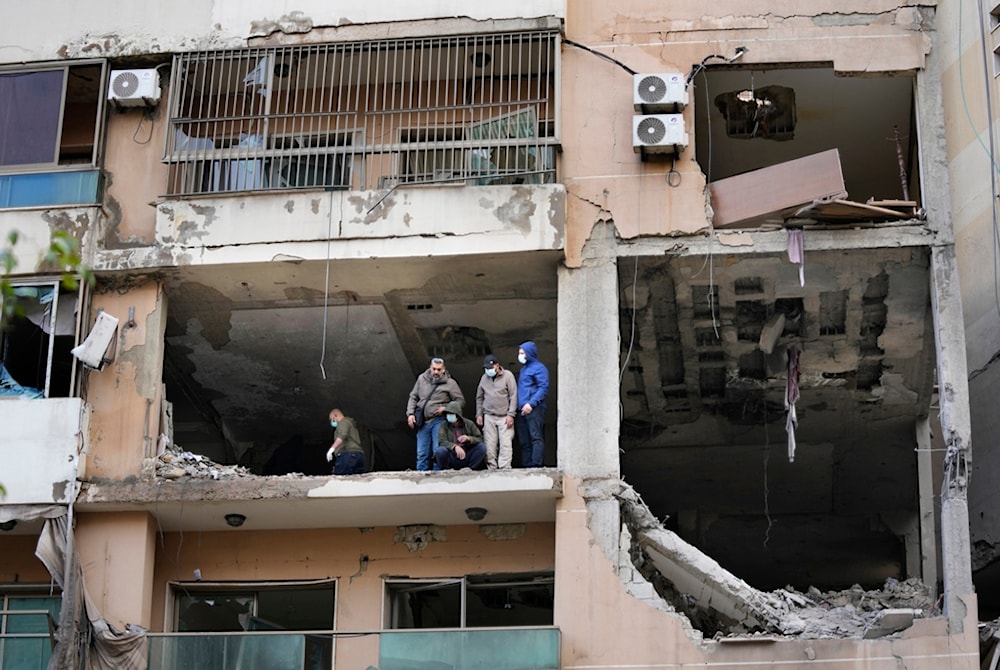 Investigators stand on an apartment building where an Israeli strike Tuesday killed top Hamas political leader Saleh al-Arouri, in the southern suburb of Beirut, Lebanon, January 3, 2024 (AP)