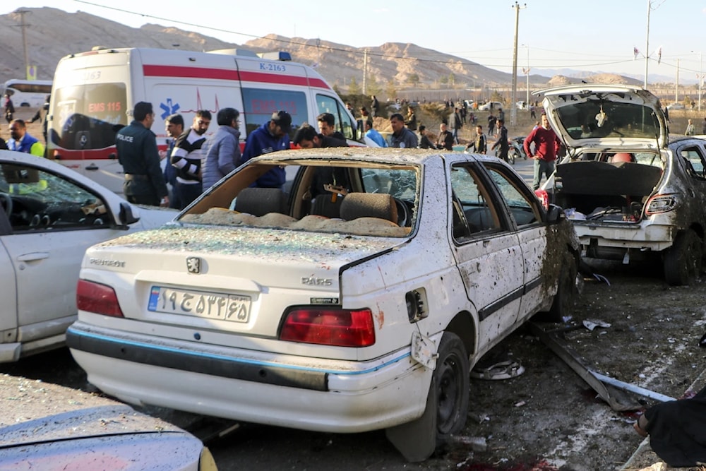 People stand next to destroyed cars after an explosion in Kerman, Iran, Wednesday, Jan 3, 2024. (AP)