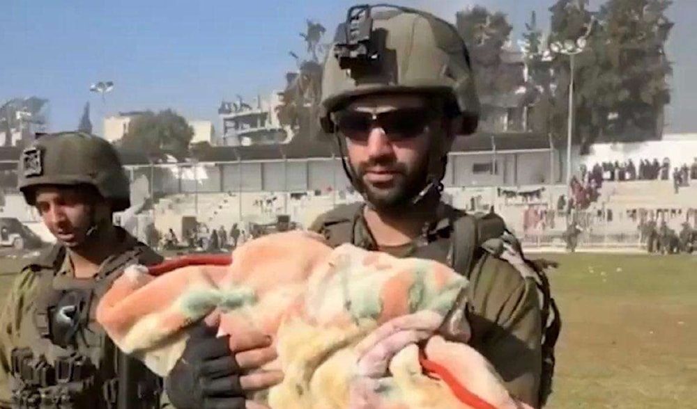Israeli soldier holding a Palestinian infant that disappeared from the Strip. (Euro-Med Humans Right Monitor)