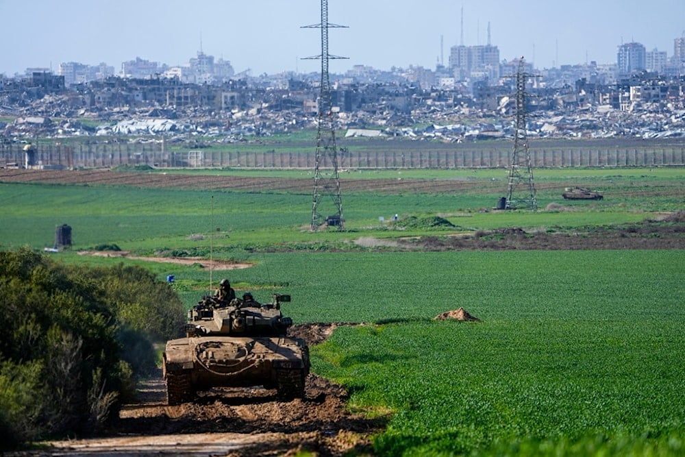 An Israeli tank drives to a position on the border with the Gaza Strip, as seen from southern occupied Palestine, Tuesday, Jan. 30, 2024. (AP Photo/Ariel Schalit)