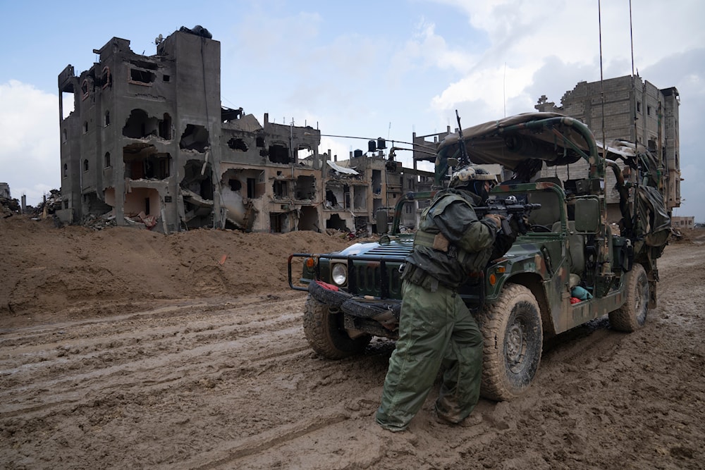 An Israeli soldier stands guard during the ground offensive on the Gaza Strip in Khan Younis, January 27, 2024 (AP)