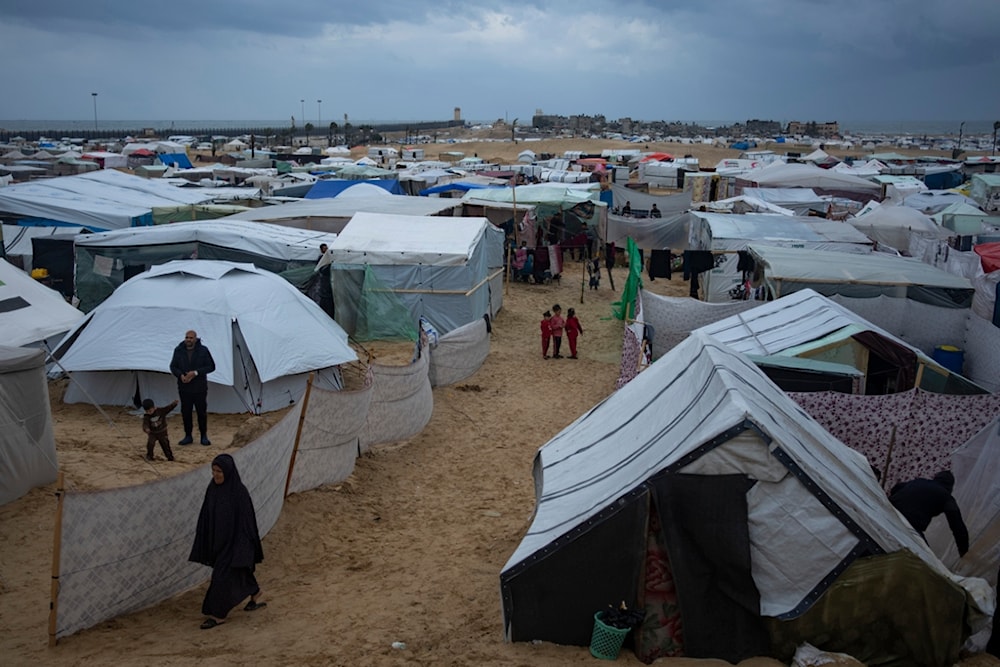 Palestinians displaced by the Israeli air and ground invasion on the Gaza Strip walk through a makeshift tent camp in Rafah on Saturday, Jan. 27, 2024. (AP Photo/Fatima Shbair)