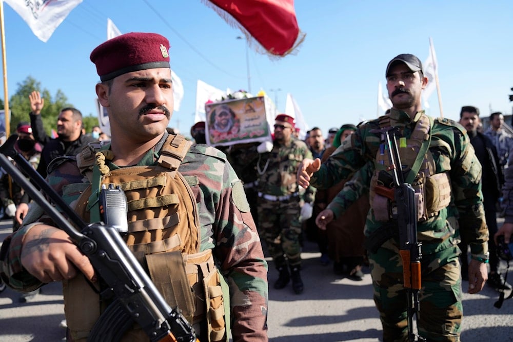 Members of an Iraqi Resistance faction group carry the coffin of a Kataib Hezbollah fighter who was killed in a US airstrike in Babil Province, during his funeral in Baghdad, Iraq, December 26, 2023 (AP)