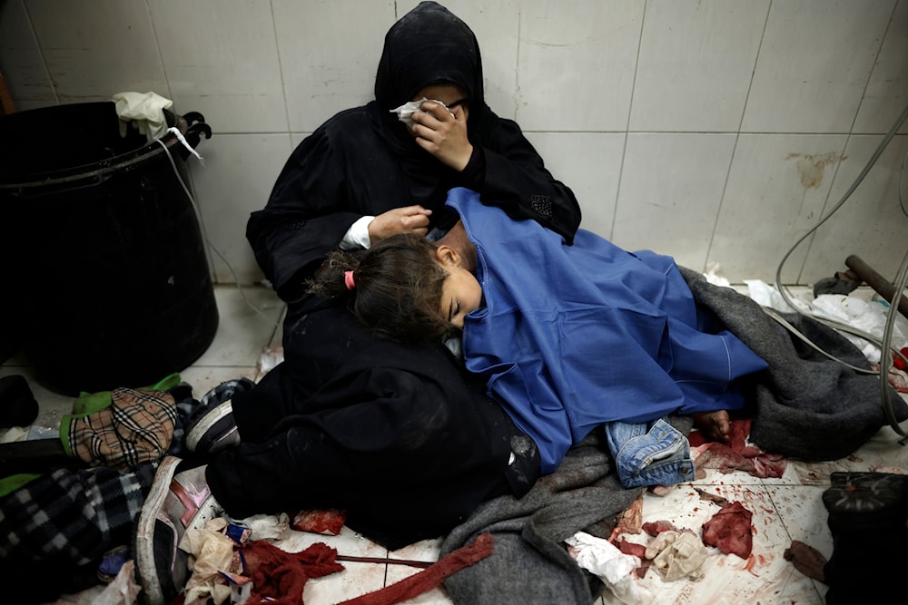 A Palestinian woman cries as she sits next to her girl wounded in the Israeli bombardment of the Gaza Strip while receiving treatment at the Nasser hospital in Khan Younis, Southern Gaza Strip, Monday, Jan. 22, 2024. (AP)