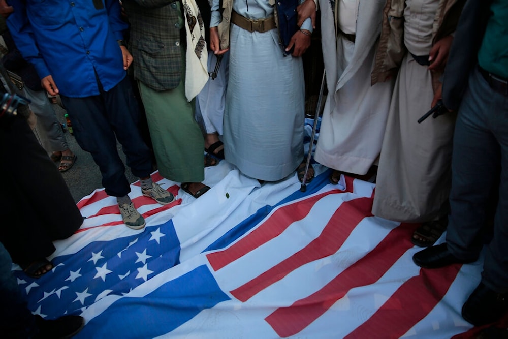 Yemenis trample on US and Israeli flags during a rally against the US-sponsored Saudi-led coalition in Sanaa, Yemen, Monday, Nov. 22, 2021 (AP)
