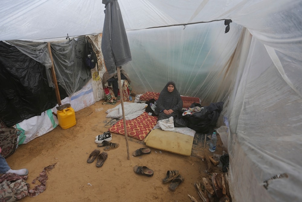 A Palestinian woman displaced by the Israeli bombardment sits in a makeshift tent in Rafah, Gaza Strip, Tuesday, Jan. 2, 2023. (AP Photo/Hatem Ali)