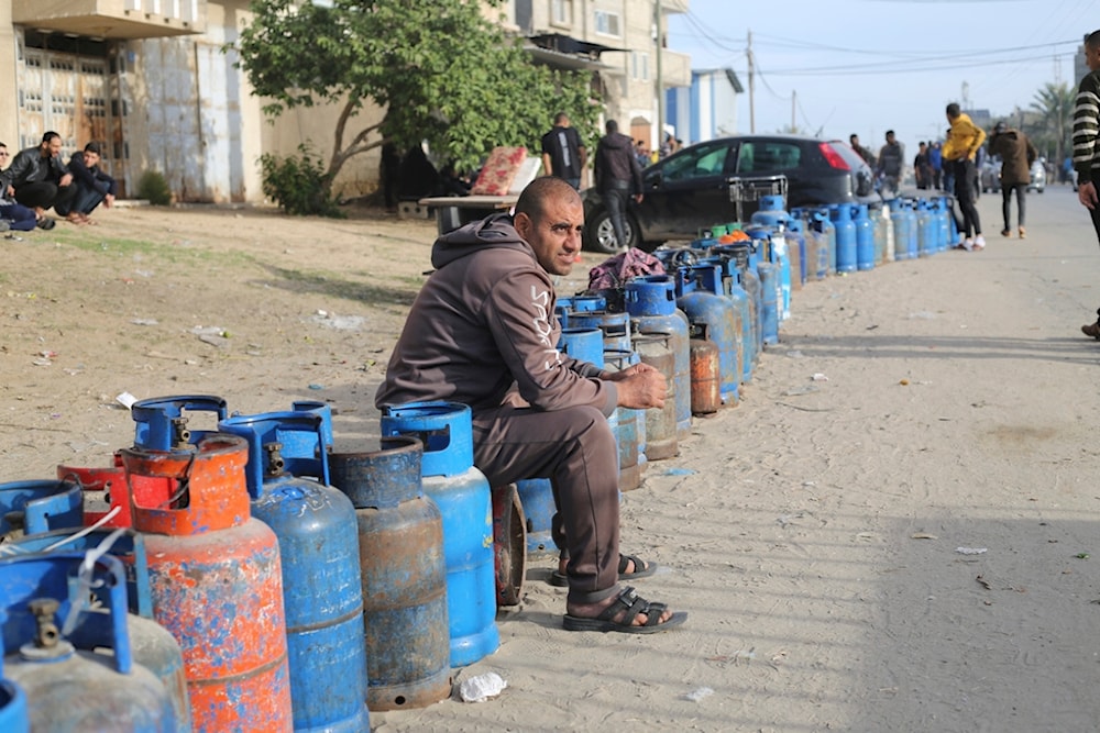 Palestinians line up for cooking gas during the second day of the truce between the resistance and the IOF in Rafah, Gaza Strip, Saturday, Nov. 25, 2023 (AP)