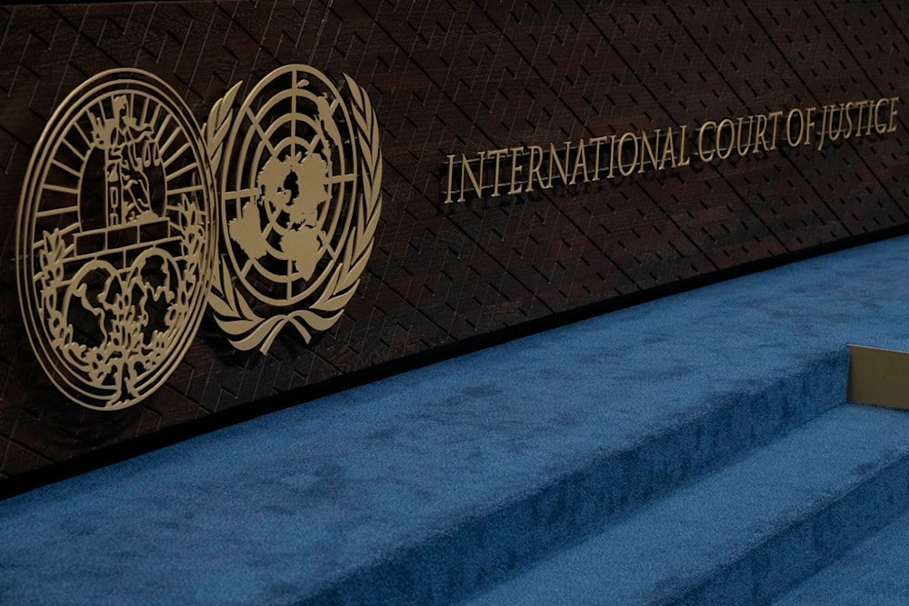 The logo of the International Court of Justice, left, and that of the U.N., right, are seen on the judges bench 